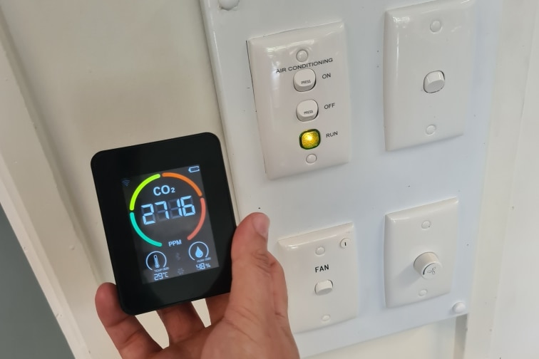 An image of a co2 monitor next to lights and fan switches reading 2716 ppm