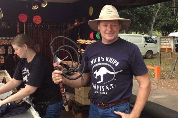 Michael Denigsan holds a stock whip and wears a Mick's Whips shirt