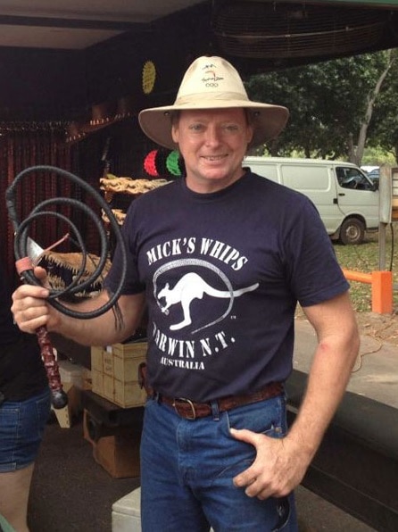 Michael Denigsan holds a stock whip and wears a Mick's Whips shirt