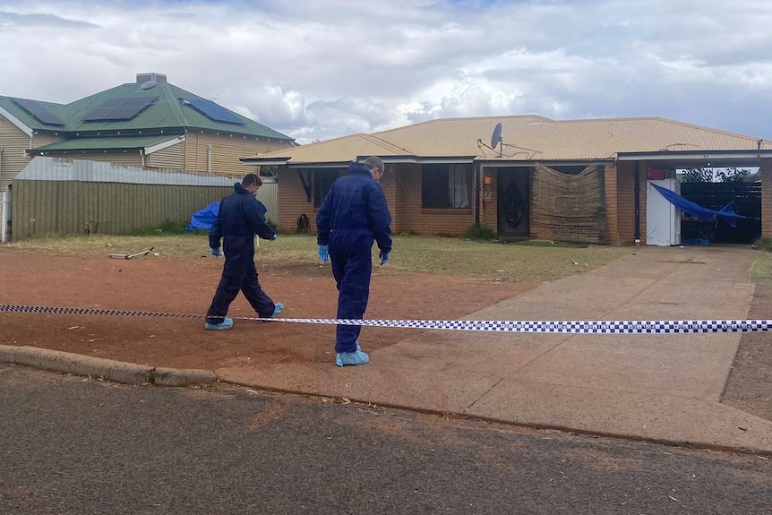 Two men in blue protective overalls walk towards a lowset house.