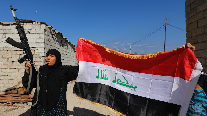 Woman with weapon and Iraqi flag in al-Alam