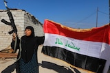 Woman with weapon and Iraqi flag in al-Alam