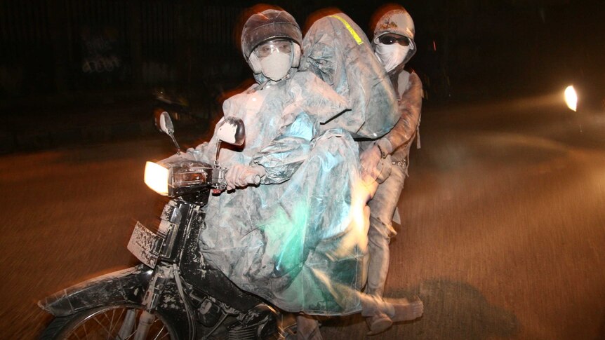 AAsh-covered Indonesians on a motorbike flee the erupting Mount Kelud in Malang, East Java province, February 14, 2014.
