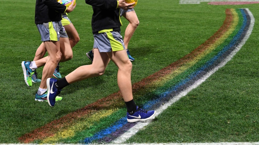 AFL umpires run past the rainbow 50-metre arc
