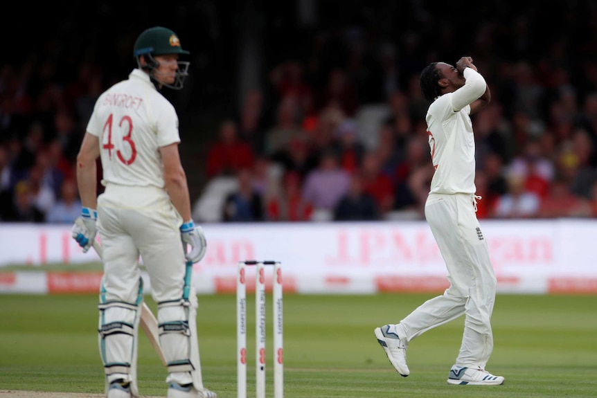 Jofra Archer holds his head in his hands as batsman Cameron Bancroft looks over his shoulder