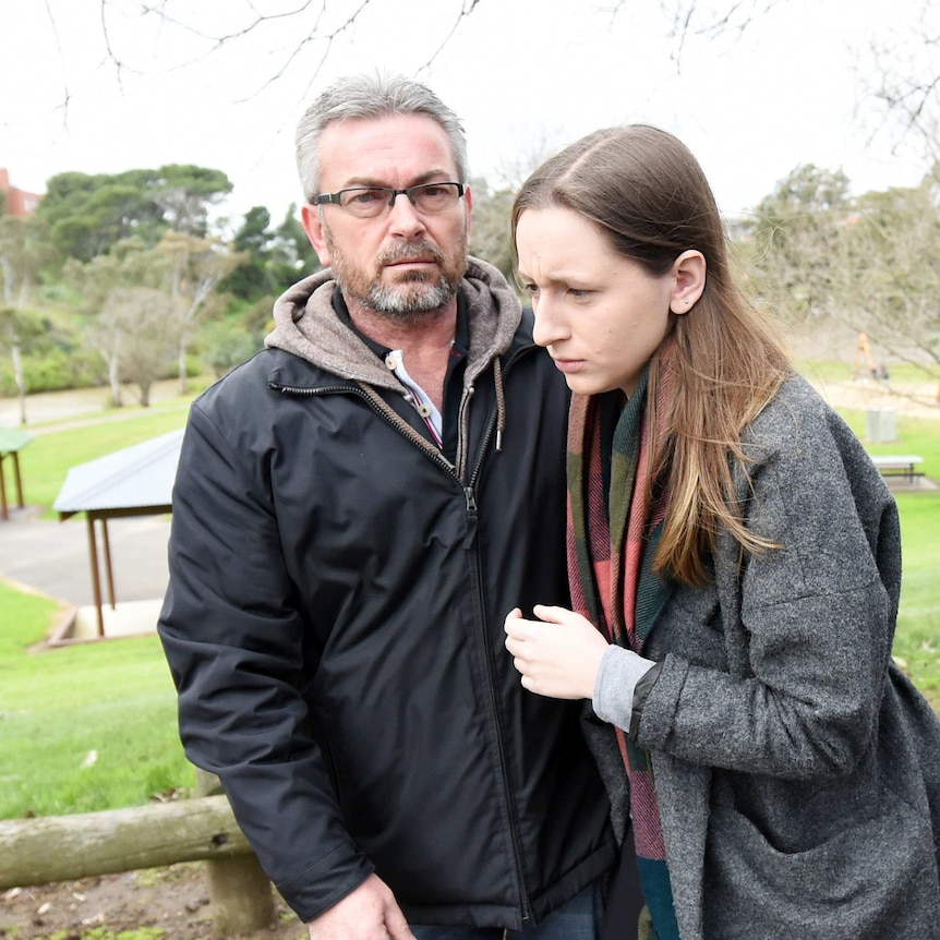 Borce Ristevski with his arm around his daughter after a press conference near the Maribyrnong River.
