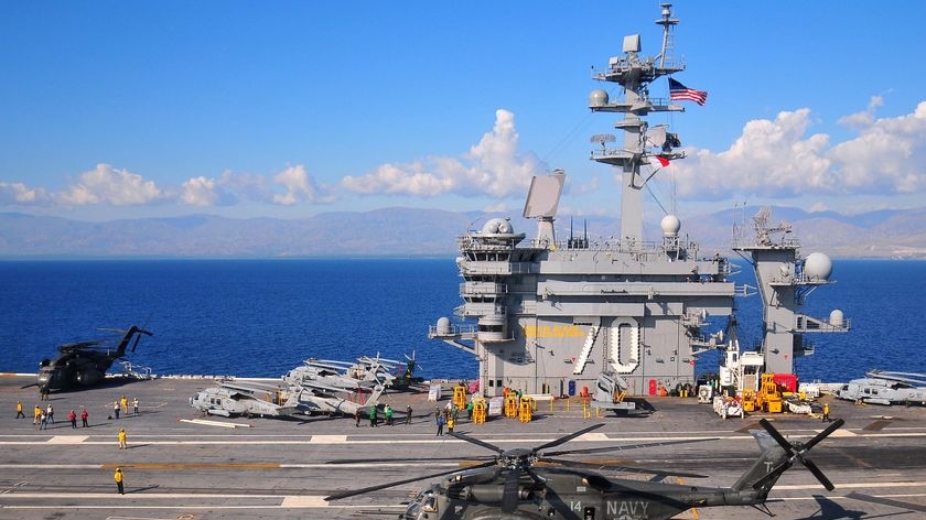 A helicopter sits on the deck of the Nimitz-class aircraft carrier USS Carl Vinson