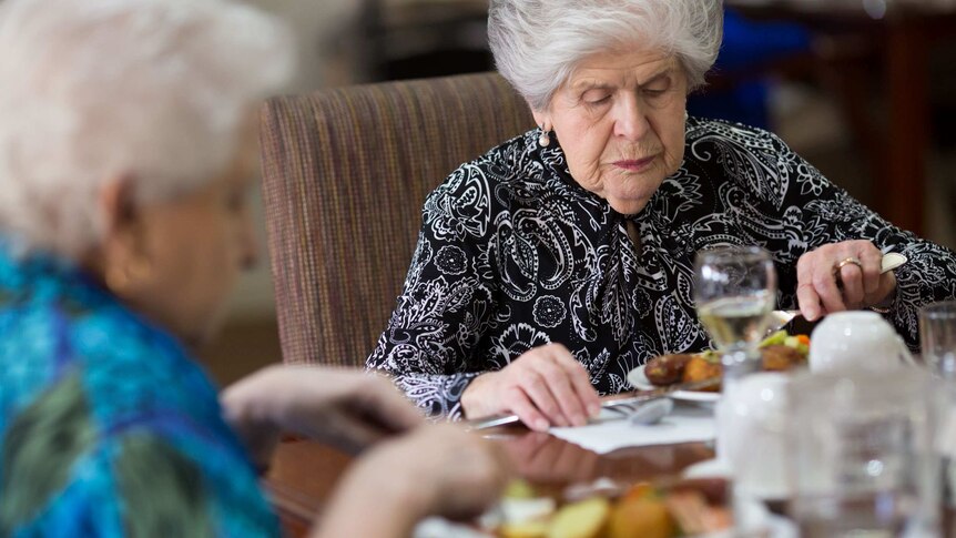 Nancy Gurciullo eating lunch at a table with other people at BlueCross Ashby nursing home.