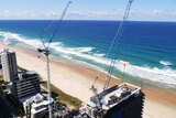 Two cranes over a building being constructed on the Gold Coast