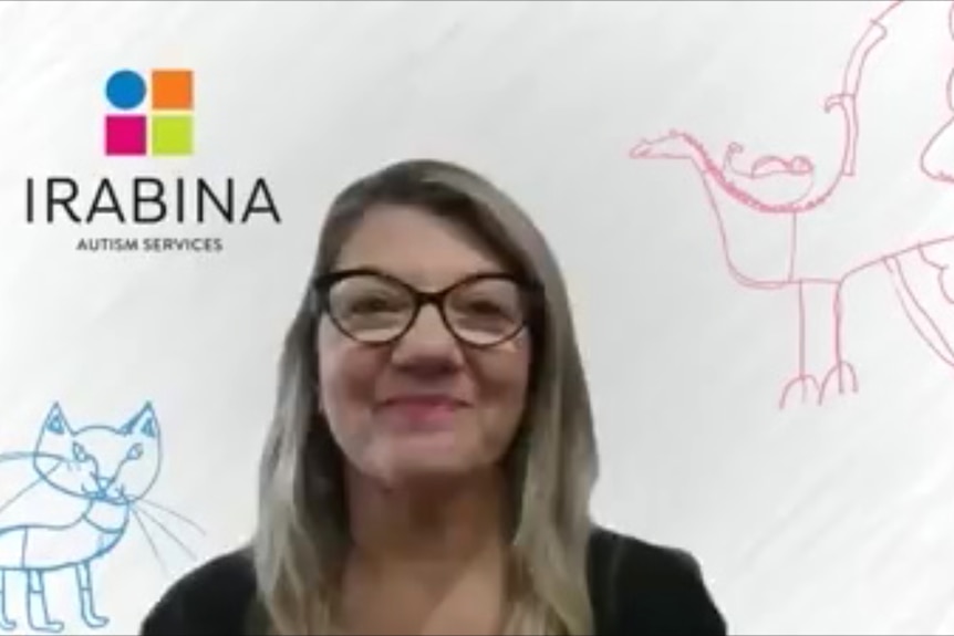 A woman smiles, in a still from a video call, with a Irabina company background behind her with children's drawings on it.