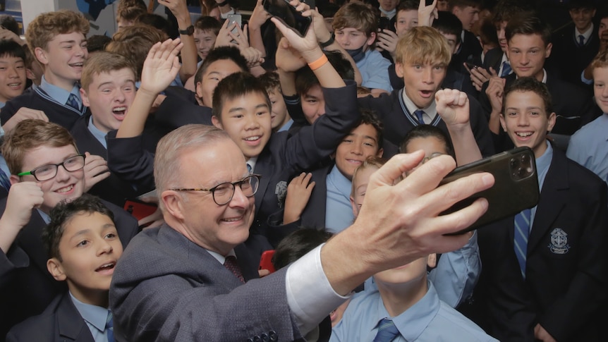 Anthony Albanese takes a selfie with school students 
