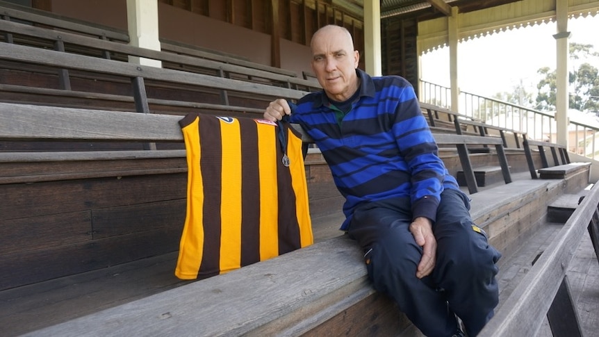 Flag winner ... Ken Judge, pictured in September 2015, with his Hawthorn premiership jersey and medal