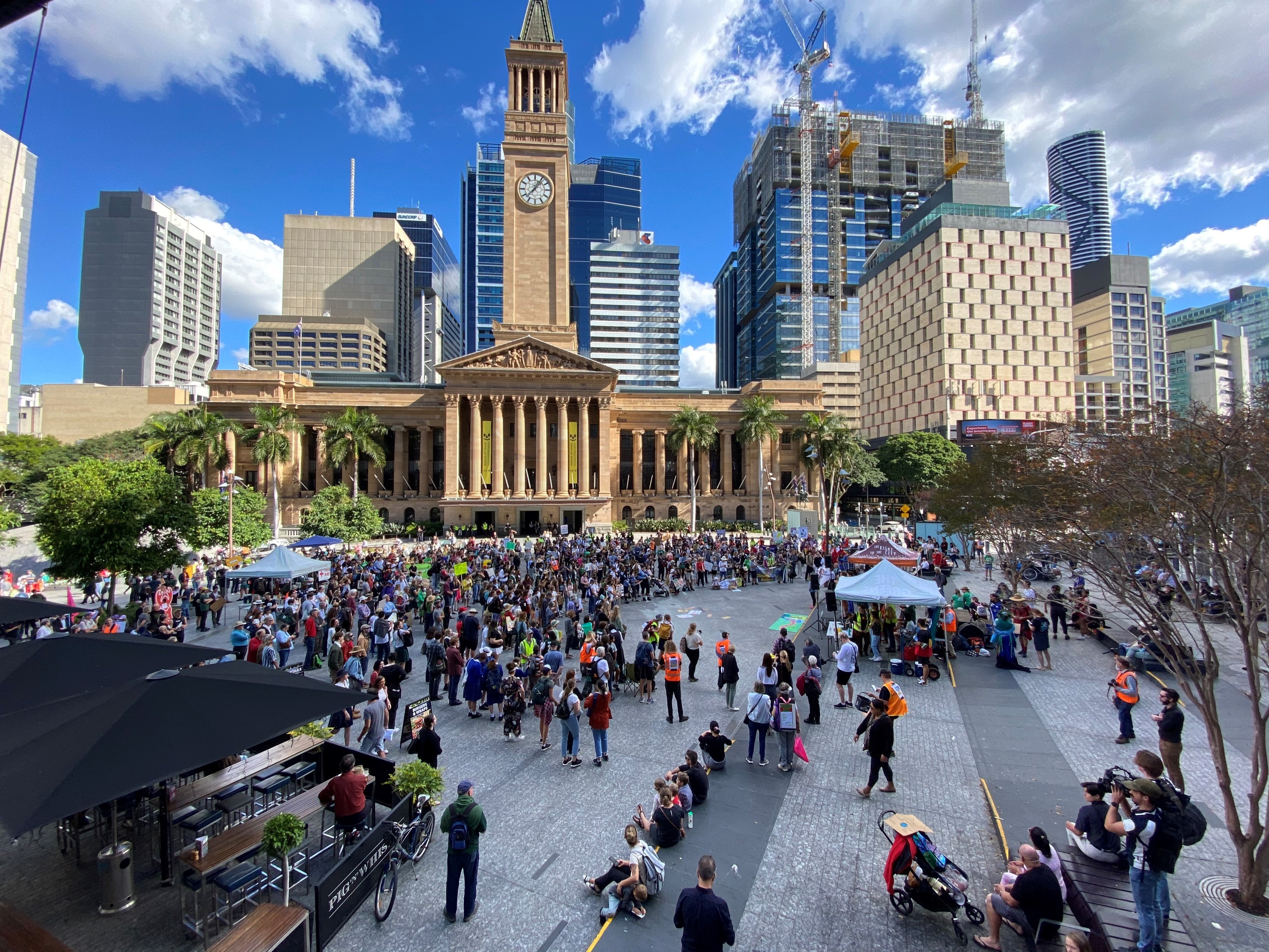 Hundreds of protesters gather in Brisbane's King George Square on a sunny afternoon.