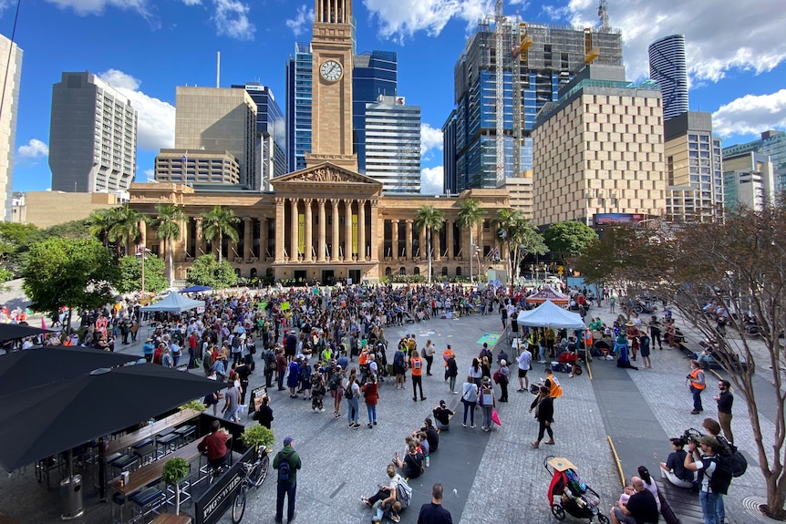 Hundreds of protesters gather in Brisbane's King George Square on a sunny afternoon.