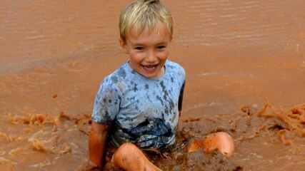 Charlie Kidd enjoying a puddle after 62 millimetres at his home Ourdel station, near Windorah.