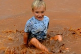 Charlie Kidd enjoying a puddle after 62 millimetres at his home Ourdel station, near Windorah.