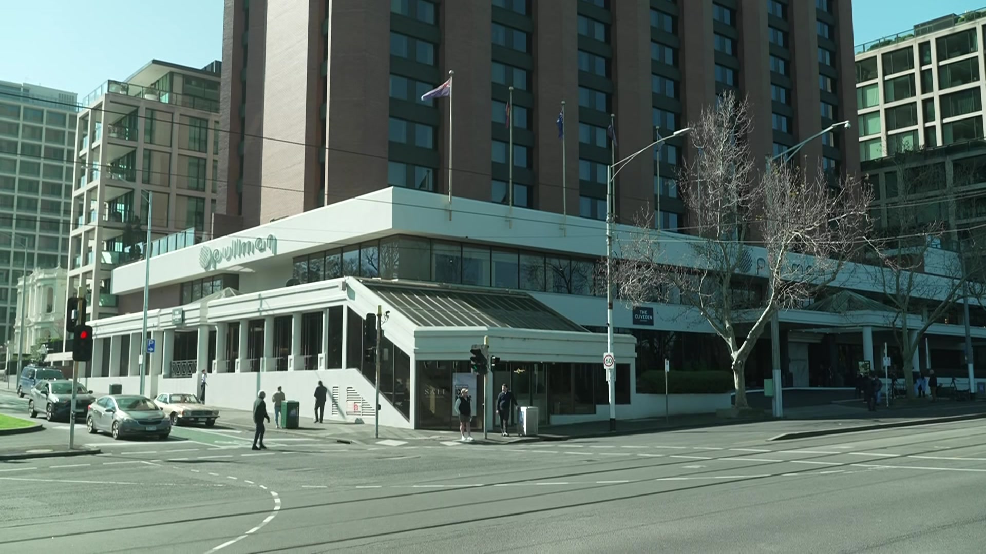 A multi-storey building on a city street corner with a sign that says 