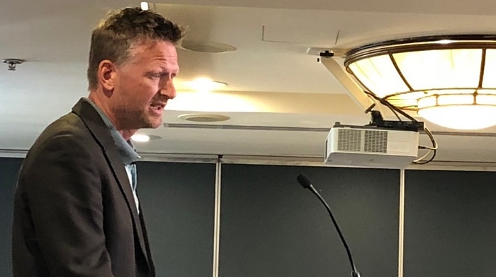 Author and former activist Mark Lynas on a podium addressing a farm conference.