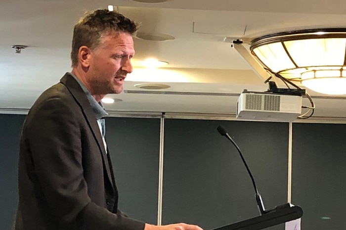 Author and former activist Mark Lynas on a podium addressing a farm conference.