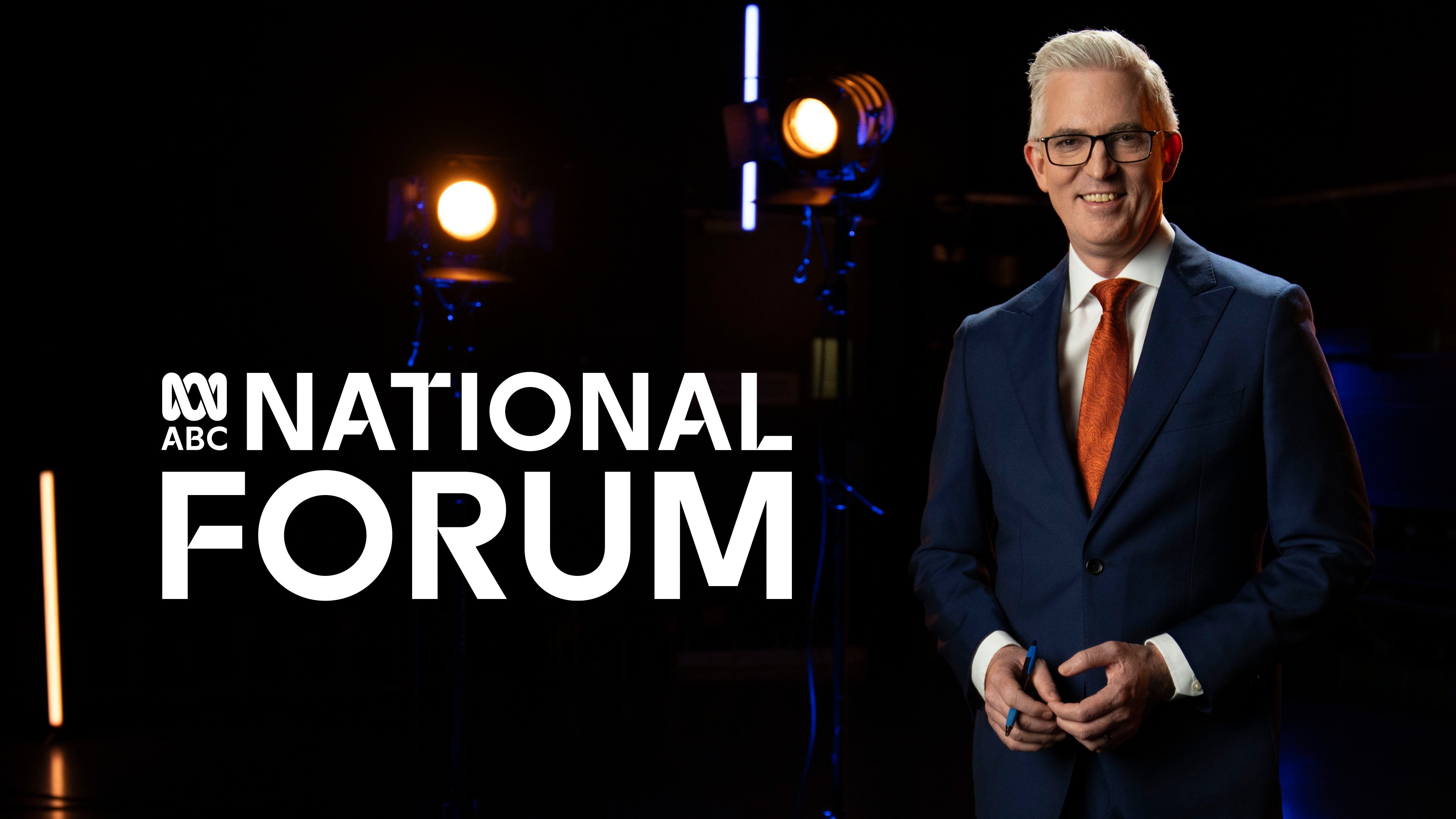Journalist David Speers in a suit stands in a studio. Text reads: ABC National Forum.