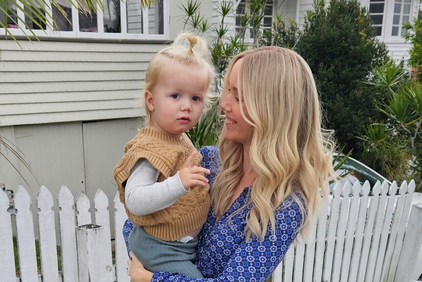 Kellie Scott and son standing outside a house