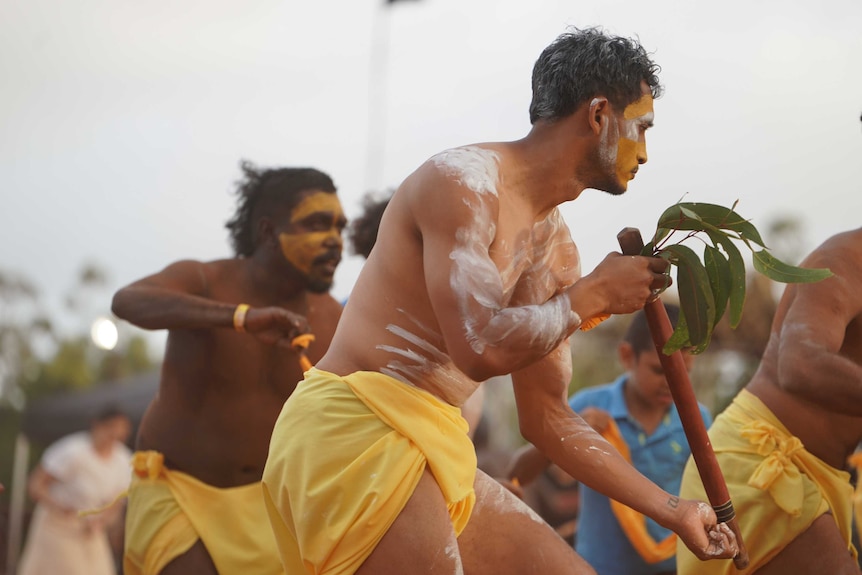 Traditionally dressed, and holding some gum leaves, the Gumatj dancer moves in unison with the other performers.