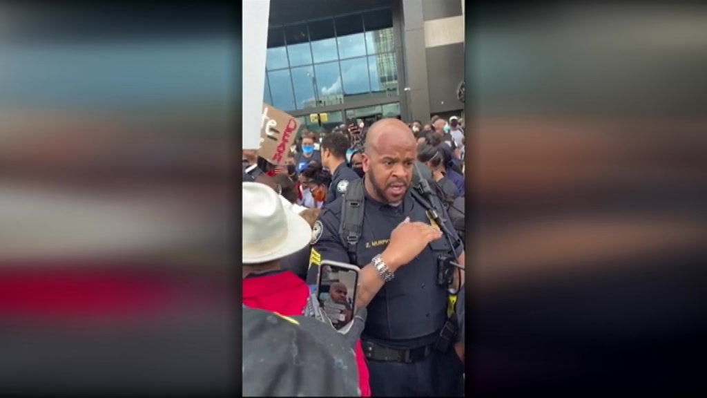 Police officer tries to calm protesters outside CNN Atlanta - ABC News