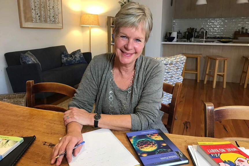 Smiling photo of Dr Karin Hammarberg, sitting at a table.