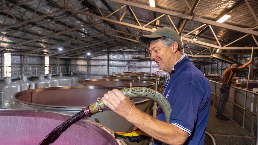 Winemaker Greg Follett pouring grape juice into tanks