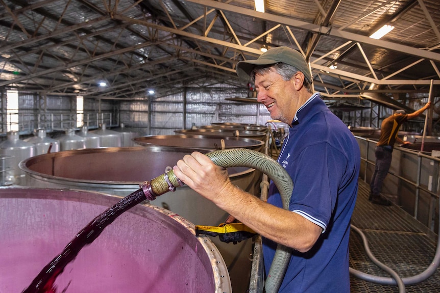 Winemaker Greg Follett pouring grape juice into tanks