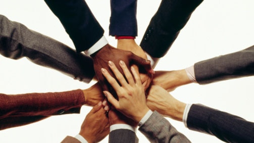 Hands of businesspeople in huddle ( Jupiterimages: Thinkstock)