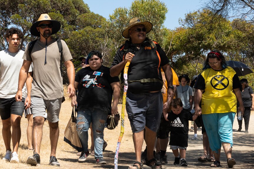 A group participating at a Yundi field day, walking in the bush