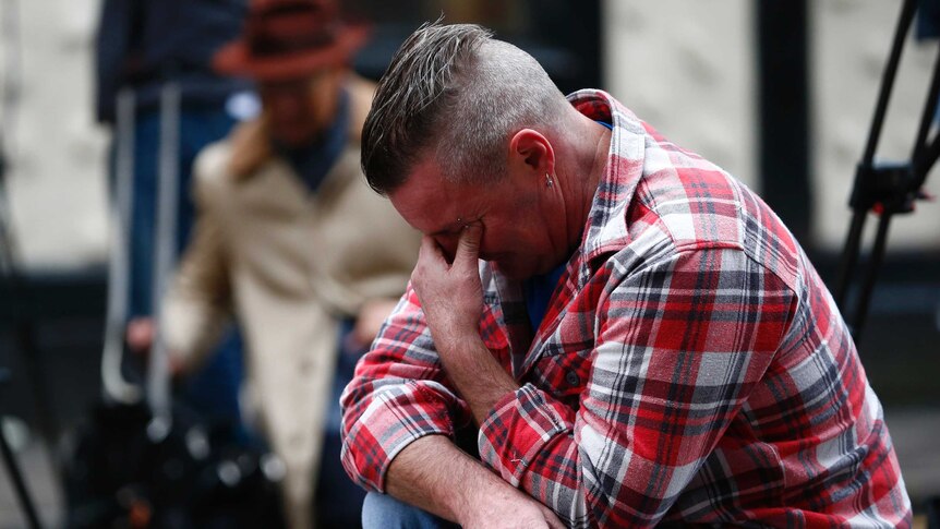 Paul Watt, a regular at The Clutha pub, mourns near the accident site.