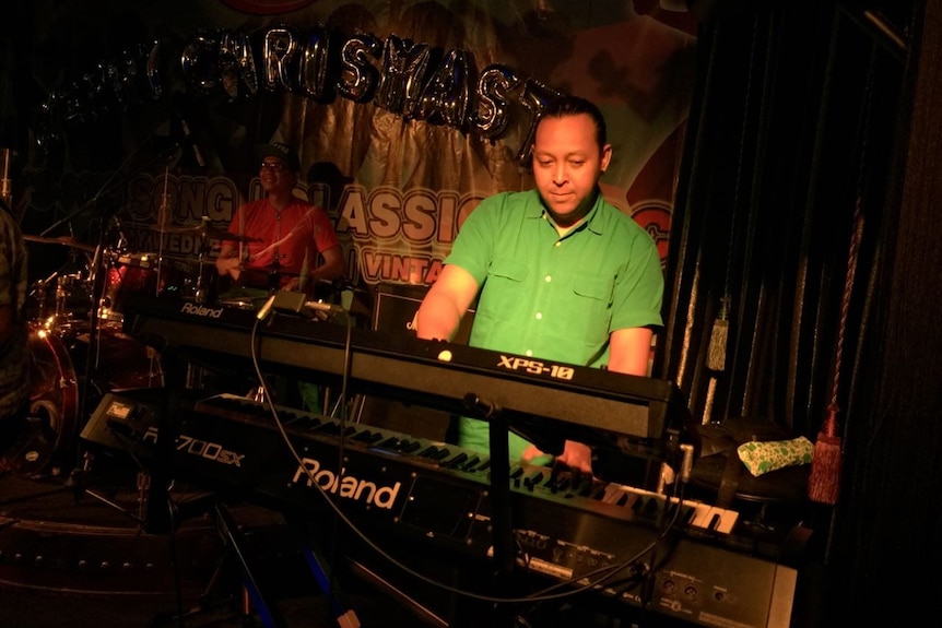 A man playing a keyboard in a cafe in Jakarta, Indonesia