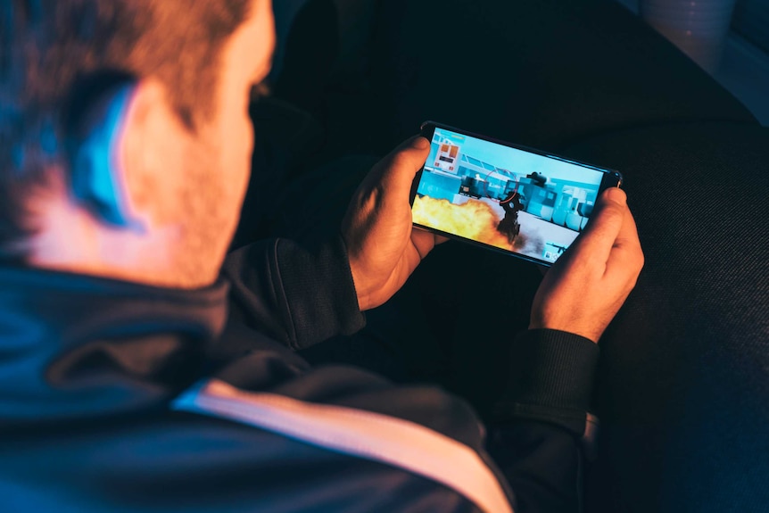 Man playing game on iphone