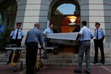 Workers carry a coffin to be used during the exhumation of Spanish artist Salvador Dali