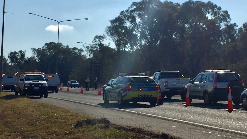 A police roadblock diverts traffic.