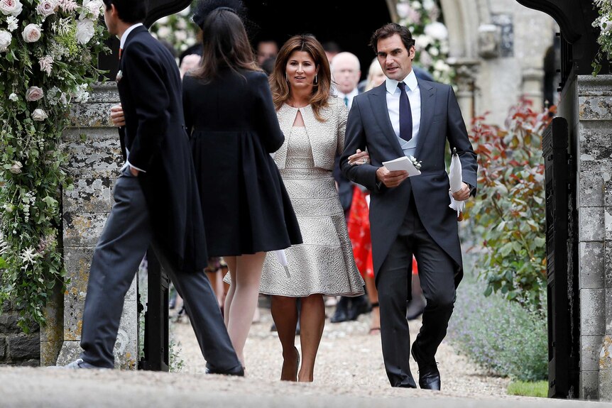 Roger Federer and his wife Mirka walk outside after the wedding, arm in arm.