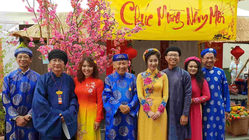 A group of men and women dressed in traditional Vietnamese clothing. 