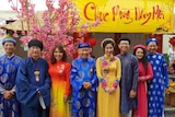 A group of men and women dressed in traditional Vietnamese clothing. 
