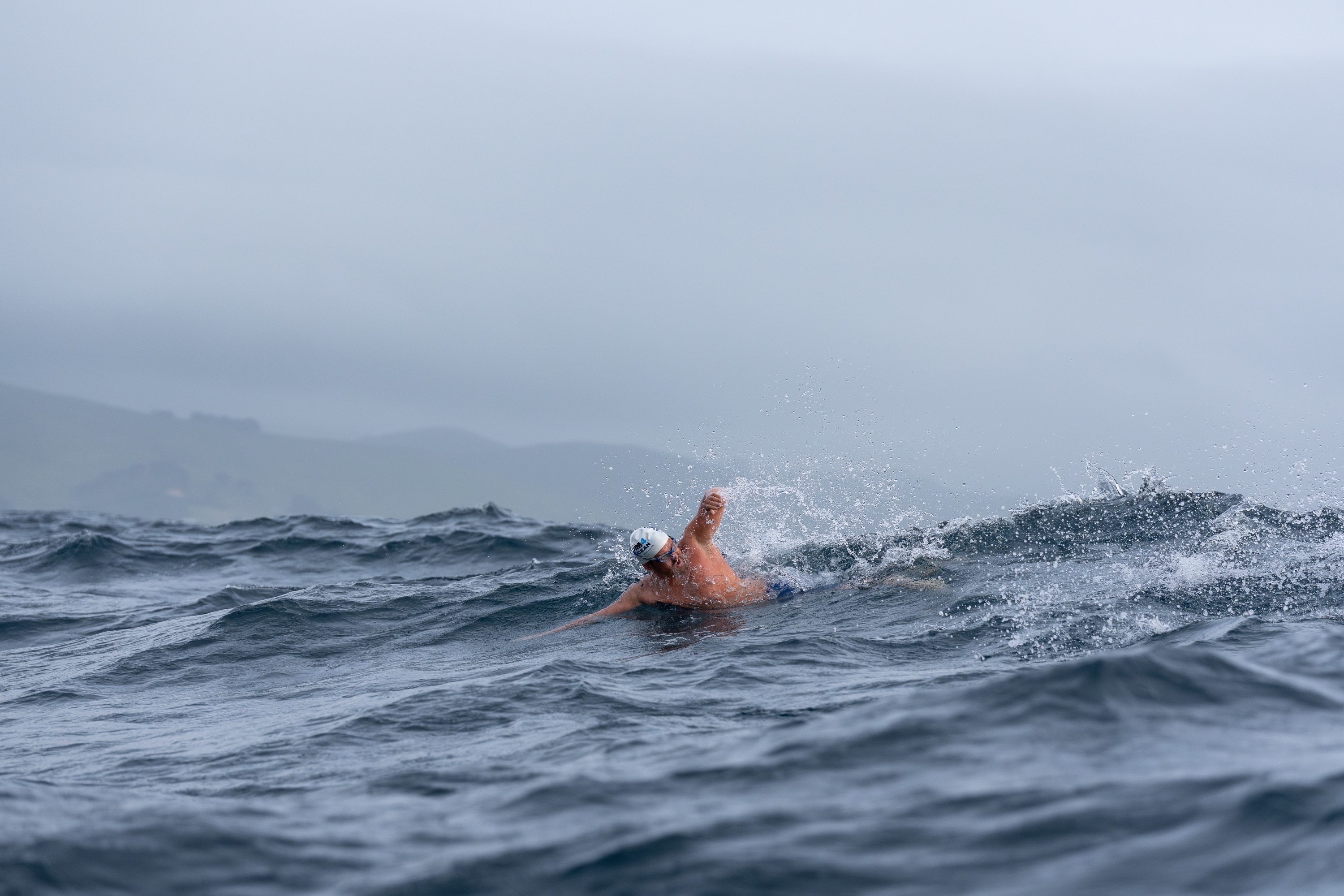 Jono Ridler swims over a wave