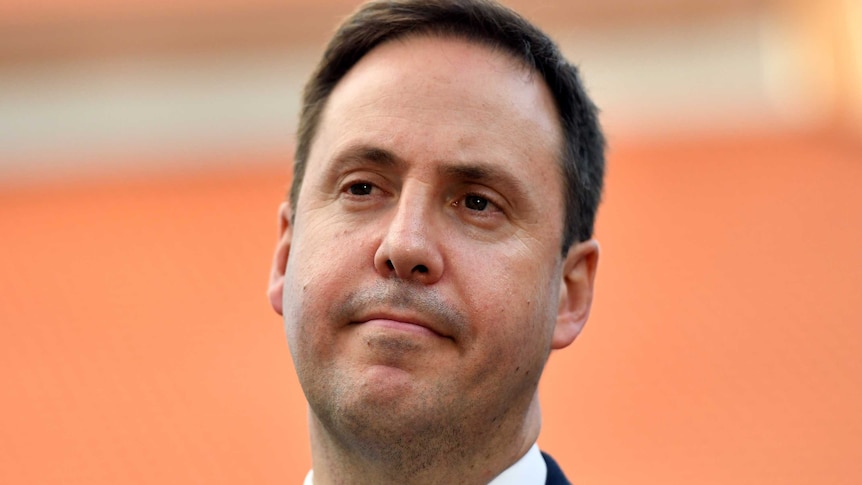 Headshot of Trade Minister Steven Ciobo in front of an orange backdrop.