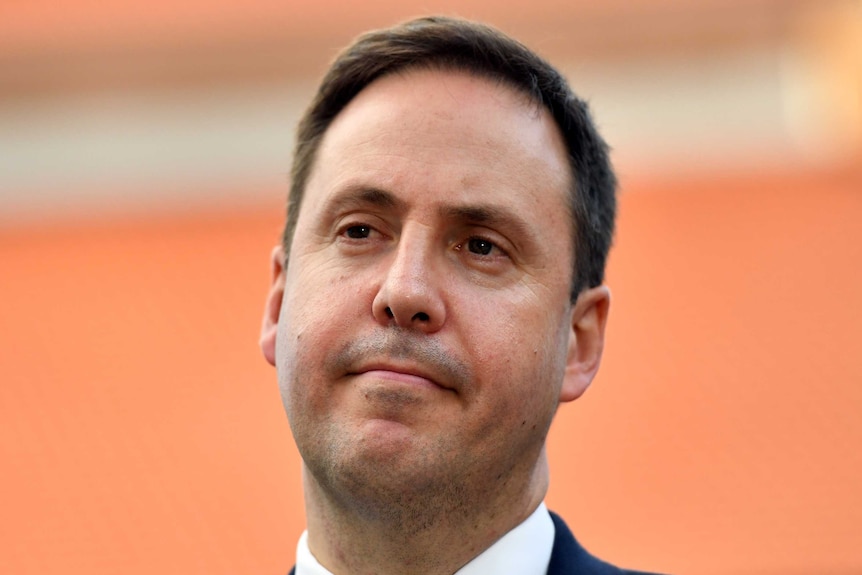 Headshot of Trade Minister Steven Ciobo in front of an orange backdrop.