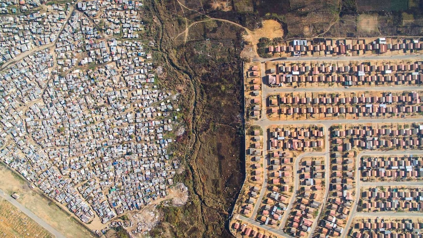 An aerial photo showing a rich neighbourhood and slums side by side