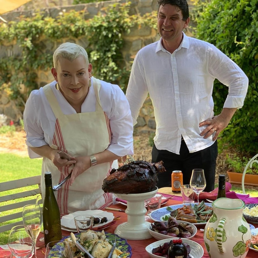 Saskia Beer and her husband Petar standing over a table with food on it