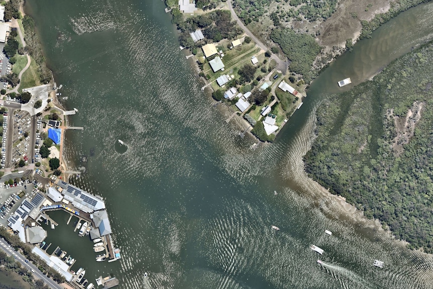 The Noosa River and buildings along its banks, including the Tewantin Noosa Marina, are seen from above.