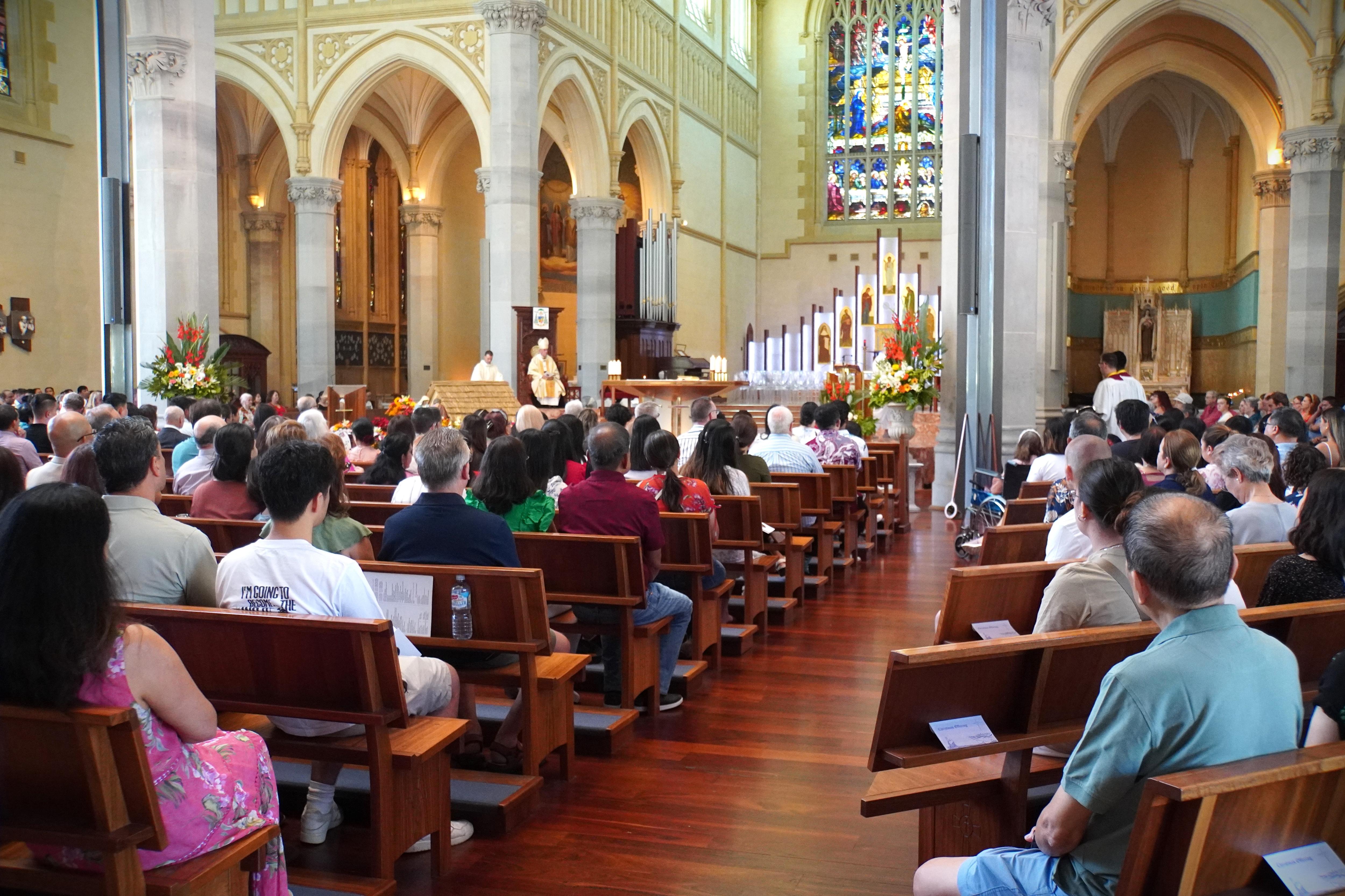 Rows of seats are filled with a crowd facing the podium.