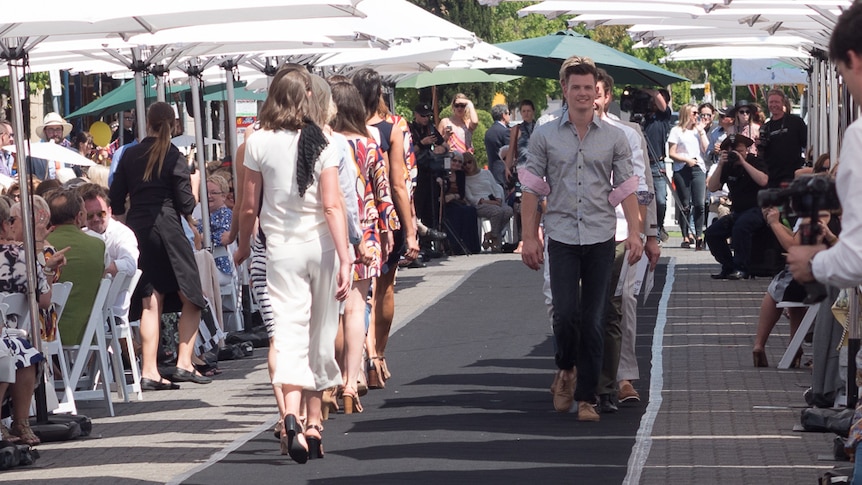 Male and female models walk the catwalk along King William Road