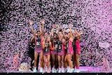 Thunderbirds players stand on the podium as pink streamers fill the air
