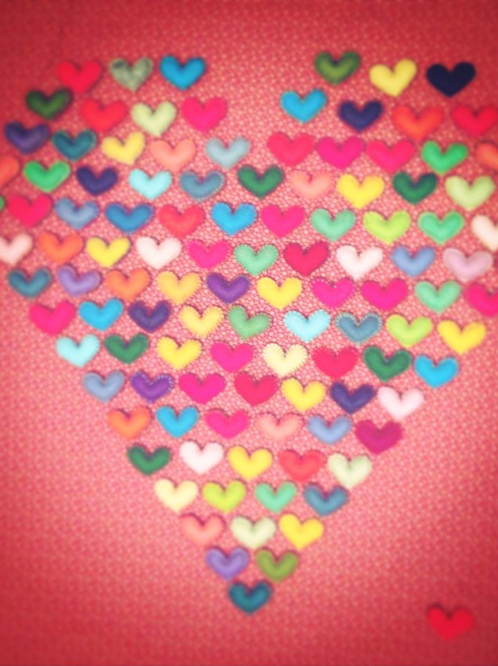 A heart shape made of small felt hearts